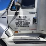 Nika Transport LLC truck delivering construction materials to a building site